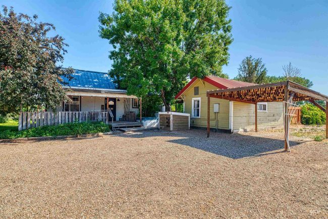 Rear view of property with a metal roof, a carport, and covered porch | Image 37