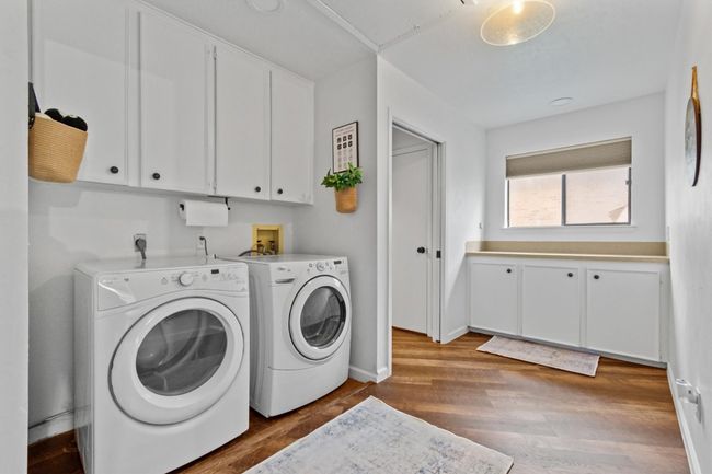 Washroom featuring cabinets, separate washer and dryer, and wood-type flooring | Image 28
