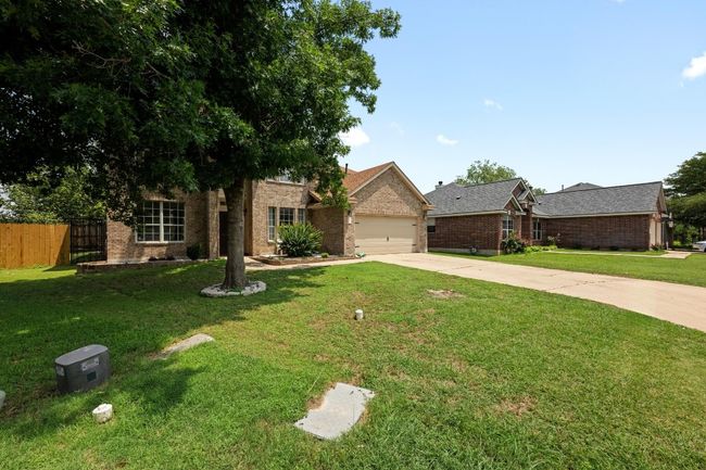View of front of property with concrete driveway, brick siding, and a garage | Image 36