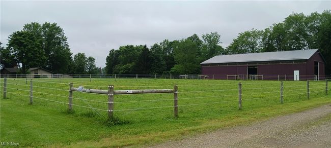 View of yard featuring an exterior structure, an outbuilding, and a view of countryside | Image 16