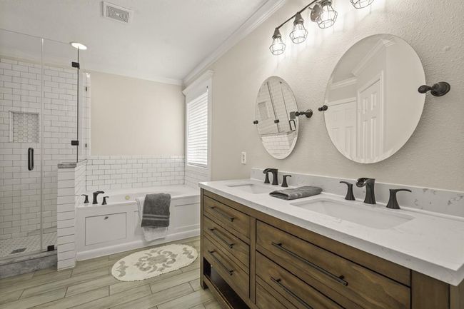 Luxurious primary bath featuring a jetted tub, spacious walk-in shower, private toilet, and expansive walk-in closet. | Image 12