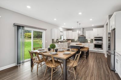 (Photo of a decorated model, actual homes finishes will vary) Soaked in natural sunlight, the homes eat-in dining room has ample space for a dining table located in the heart of the home. | Image 3