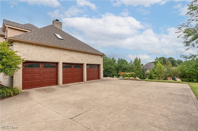 This is a view of the 3 car garage. One positive thing is the amount of driveway. Stunning garage doors. | Image 42
