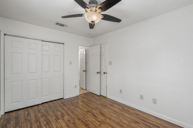 Unfurnished bedroom featuring visible vents, baseboards, dark wood-style floors, and a closet | Image 18