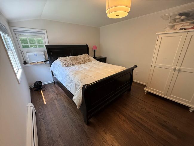 Beautiful hardwood floors and large windows create a serene bedroom space. | Image 19