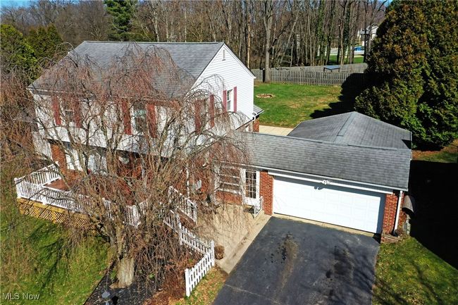 View of front of property featuring driveway, a front yard, fence, an attached garage, and a shingled roof | Image 8