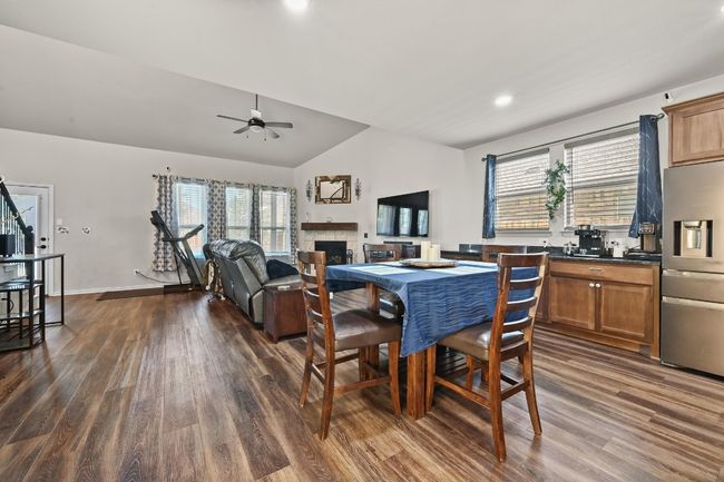 Dining space with a fireplace, dark wood-style flooring, a ceiling fan, vaulted ceiling, and recessed lighting | Image 9