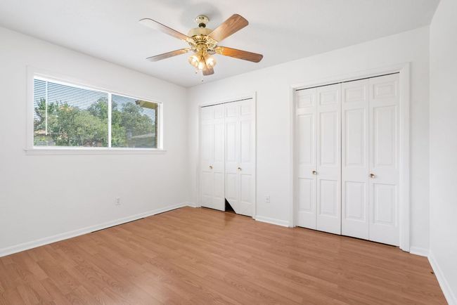 Bedroom 2 featuring light wood finished floors, two closets, and ceiling fan | Image 23
