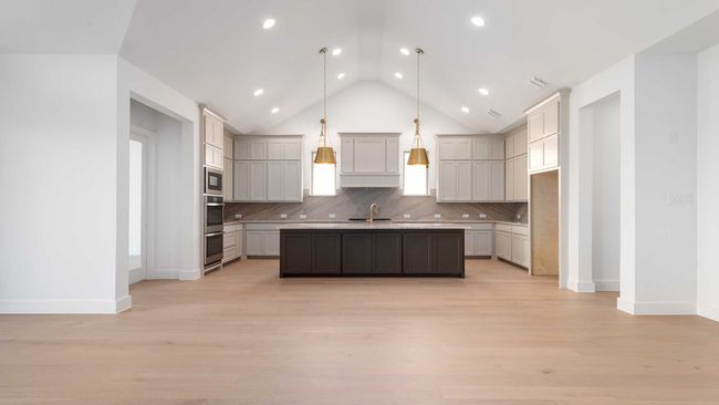 Kitchen featuring appliances with stainless steel finishes, baseboards, lofted ceiling, and backsplash | Image 14