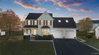 View of front facade with a yard, a porch, and a garage | Image 1