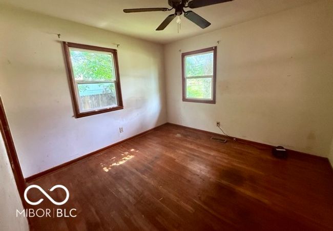 Just one of three cozy bedrooms with hardwood floors and natural light, offering a blank canvas for your personal style and comfort. | Image 8