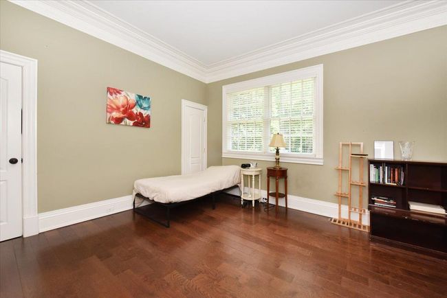 Living area featuring wood finished floors, ornamental molding, a high end fireplace, and recessed lighting | Image 9