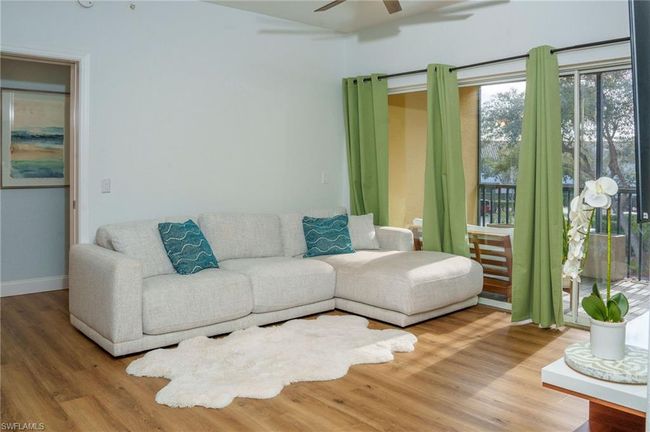 Living area with baseboards, a ceiling fan, and wood finished floors | Image 18