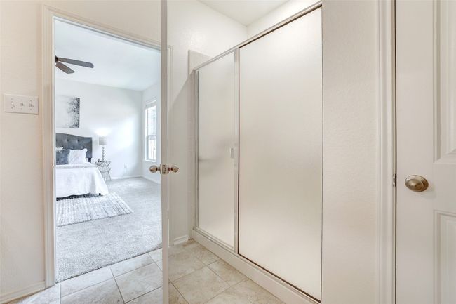 Ensuite bathroom with a stall shower, a ceiling fan, and tile patterned floors | Image 28