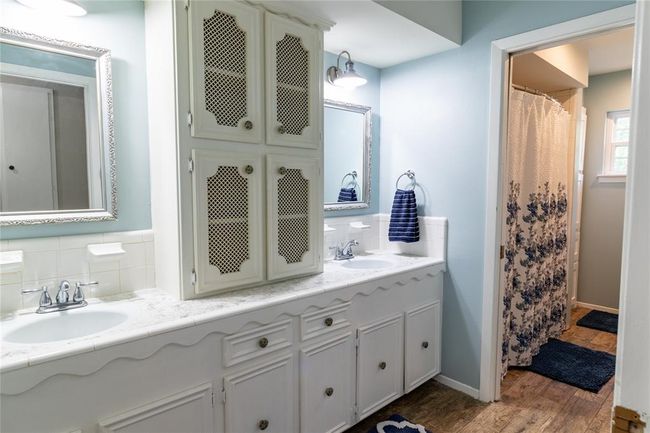 Upstairs bath with double sinks. Adjacent bedroom has a separate vanity with sink. | Image 17