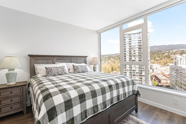 Bedroom with baseboards, dark wood-type flooring, a view of city, and multiple windows | Image 14