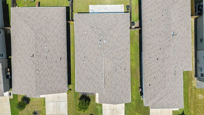 A top-down aerial shot of the home and its neighbors, clearly showing the brand new roof installed in July 2025. | Image 29