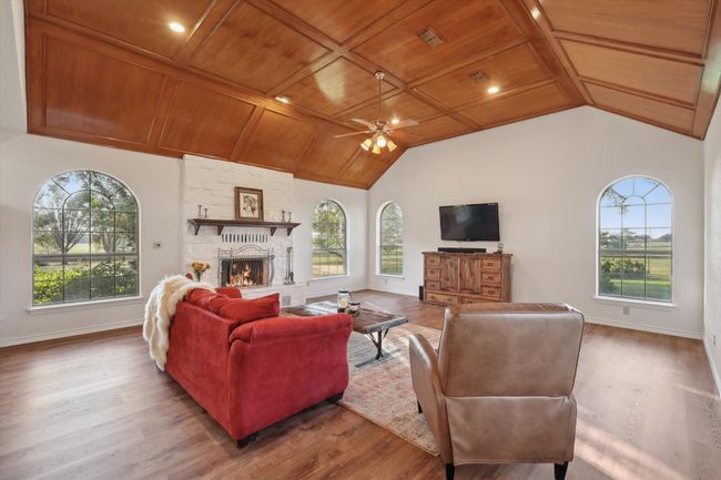 Living area featuring wood ceiling, vaulted ceiling, ceiling fan, wood finished floors, and a stone fireplace | Image 18