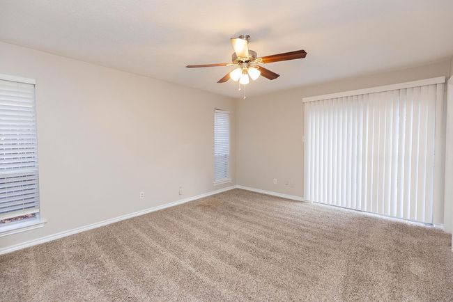 Carpeted empty room featuring ceiling fan and baseboards | Image 15