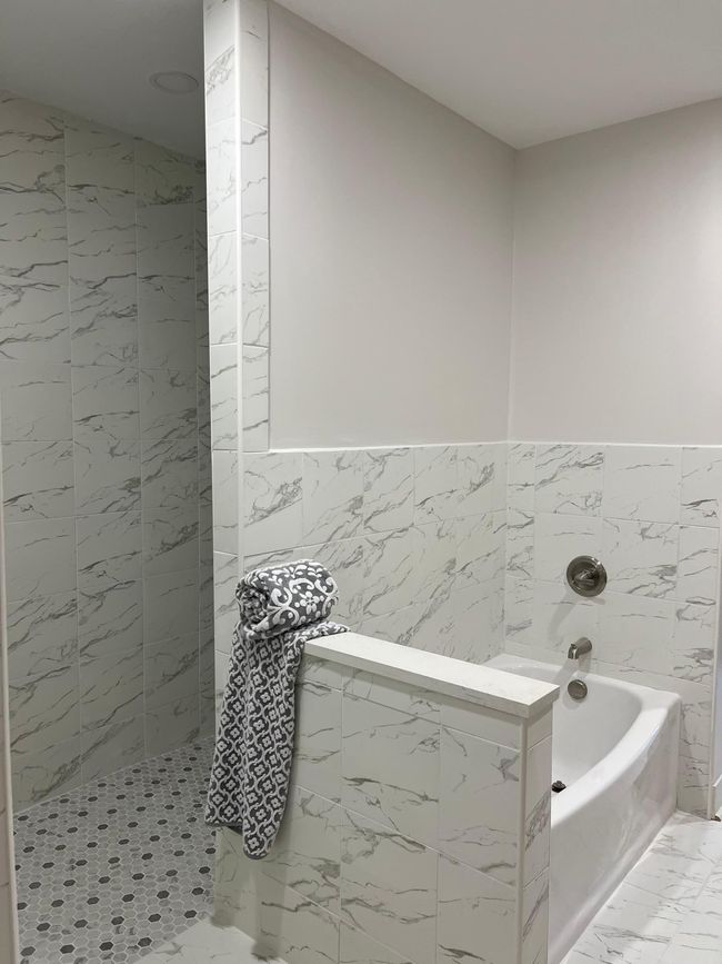 Soaking tub and massive tiled shower behind with linear drain | Image 11
