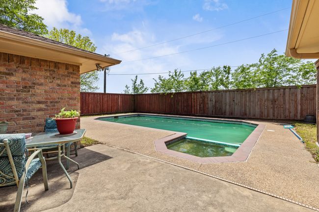 View of swimming pool with a patio area, a fenced in pool, and a fenced backyard | Image 33