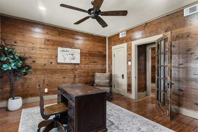 Office featuring ceiling fan, wooden walls, wood finished floors, and baseboards | Image 20