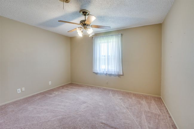 Carpeted spare room featuring a textured ceiling and ceiling fan | Image 16