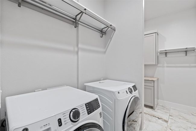 Laundry area with independent washer and dryer, light marble finish flooring, and baseboards | Image 28
