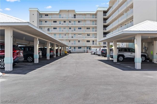 The property includes a convenient covered carport, providing easy and secure parking close to the building entrance. | Image 7