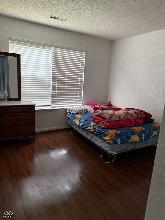 bedroom featuring wood finished floors and a textured ceiling | Image 10