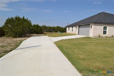 A concrete driveway leads to the two car, side entry garage. | Image 2