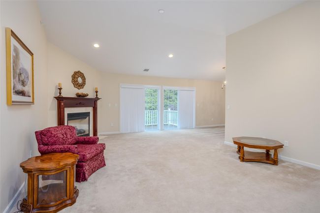 Sitting room with a glass covered fireplace, carpet flooring, and recessed lighting | Image 6