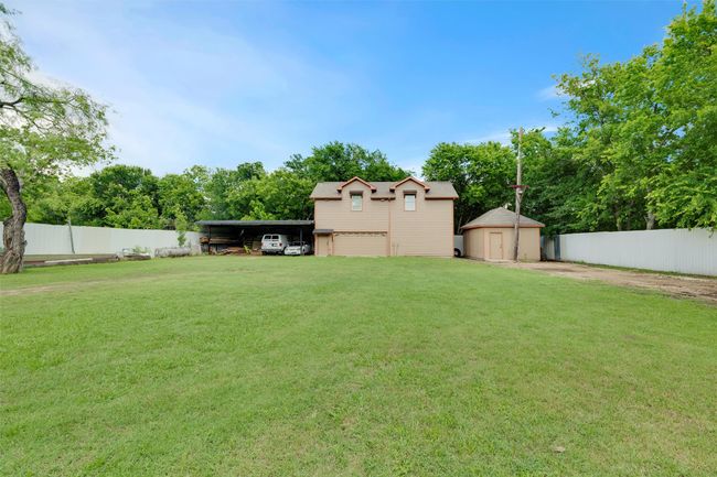 View of yard featuring a carport, driveway, and view of scattered trees | Image 35
