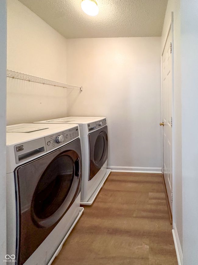 laundry room with independent washer and dryer, laundry area, baseboards, and light wood-type flooring | Image 14