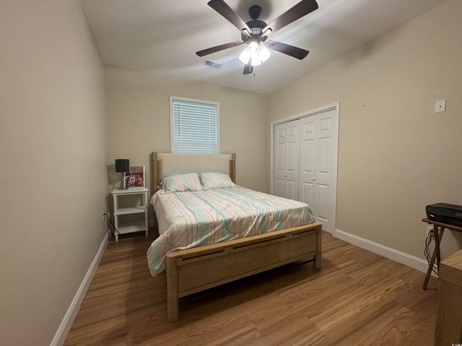 Bedroom with baseboards, wood finished floors, a closet, and ceiling fan | Image 13