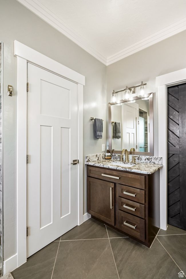 Bathroom with crown molding, tile patterned floors, and vanity | Image 42