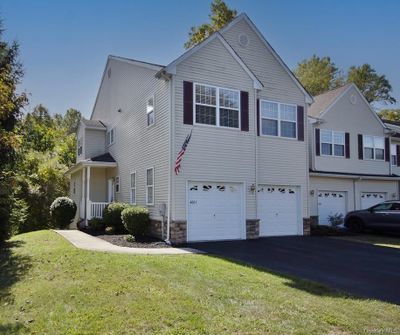 Front of townhouse and end unit featuring 2-car garage and front lawn | Image 1