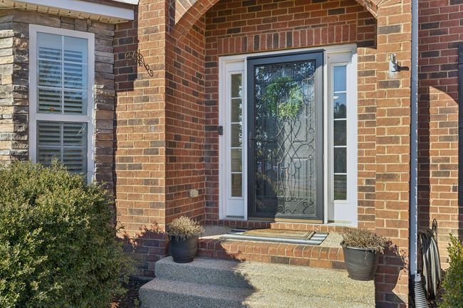 The front door makes an impressive first impression with this storm door and it's beautiful iron work. | Image 5