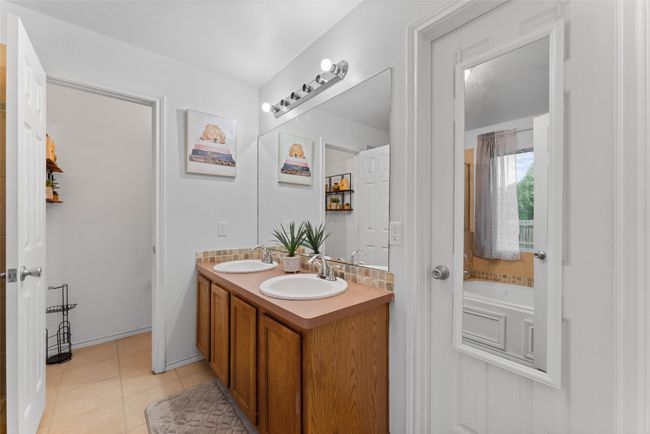 Bathroom featuring double vanity, tile patterned flooring, and a bath | Image 18