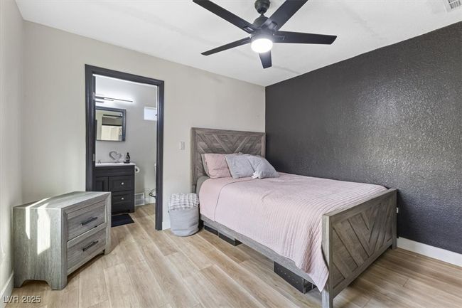 Bedroom with visible vents, baseboards, ensuite bath, and light wood-style flooring | Image 16