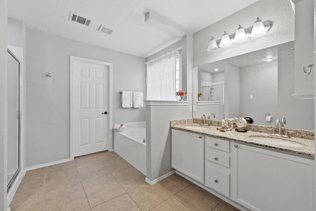 Primary ensuite bathroom with a stall shower, a garden tub, tile patterned floors, and double vanity | Image 17