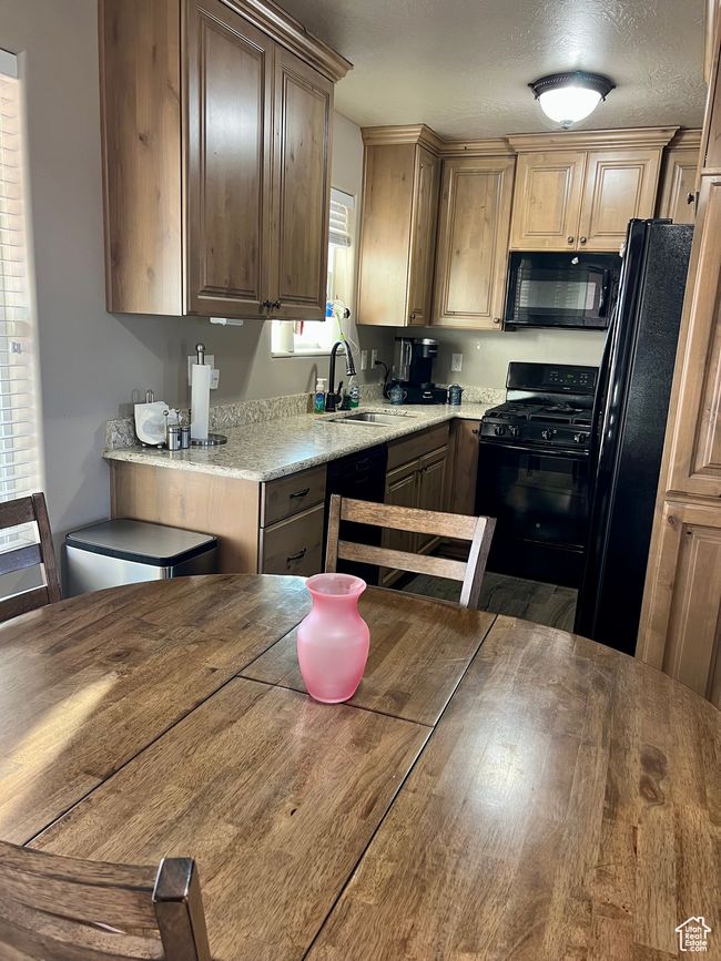 Kitchen with black appliances and wood finished floors | Image 24