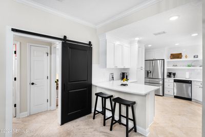 Kitchen center of family & friend activity. Breakfast bar/island or workspace. Note Barn Doors to Guest Bedrooms suite used for privacy. | Image 3