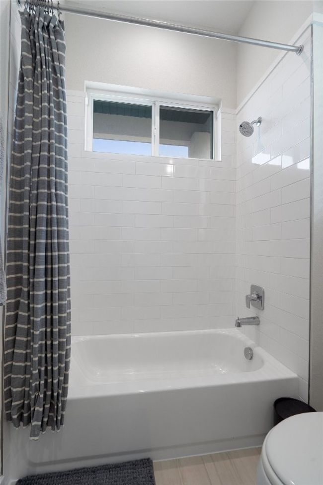 Full bathroom featuring shower / bathtub combination with curtain and toilet | Image 34