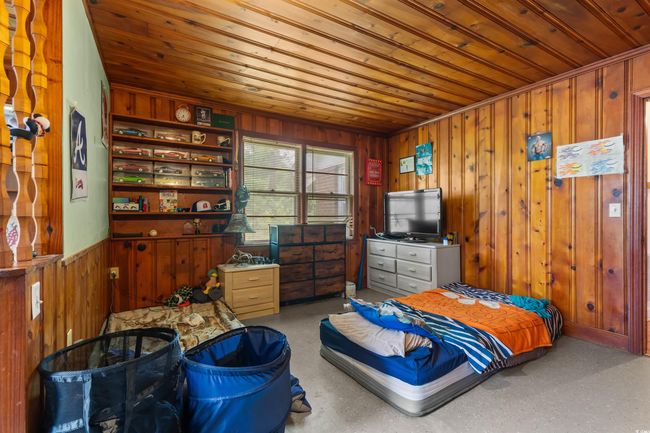 Bedroom featuring wood ceiling and wood walls | Image 33