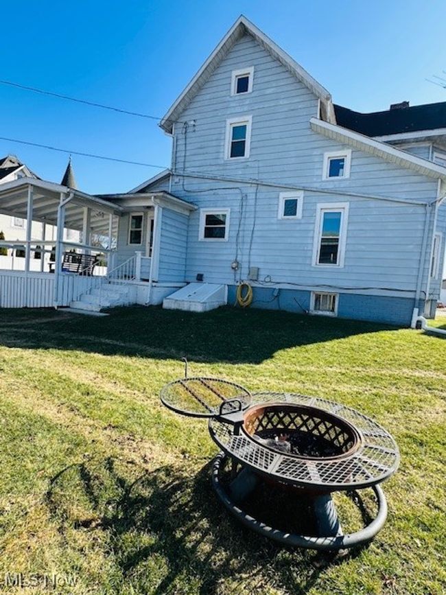 Rear view of property with firepit for entertaining. | Image 35