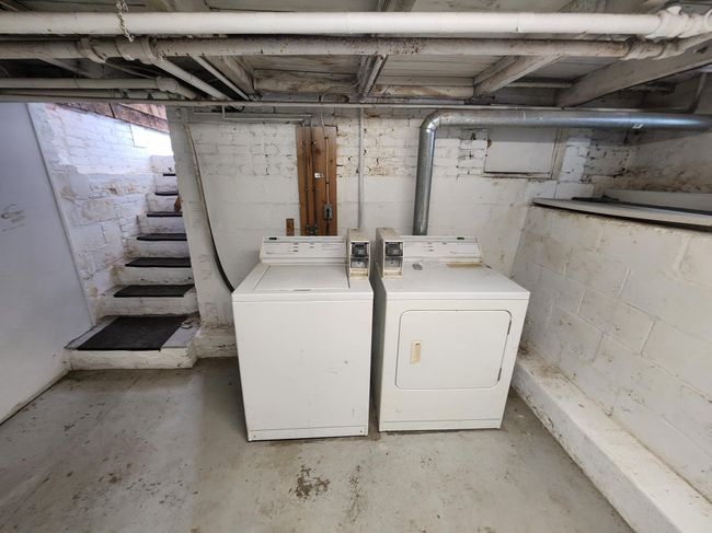 Unfinished basement featuring washing machine and dryer and stairs | Image 5