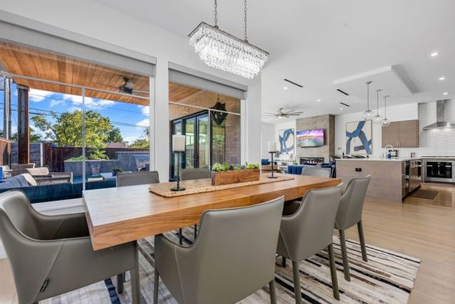 Dining space featuring ceiling fan with notable chandelier and light wood-type flooring | Image 14