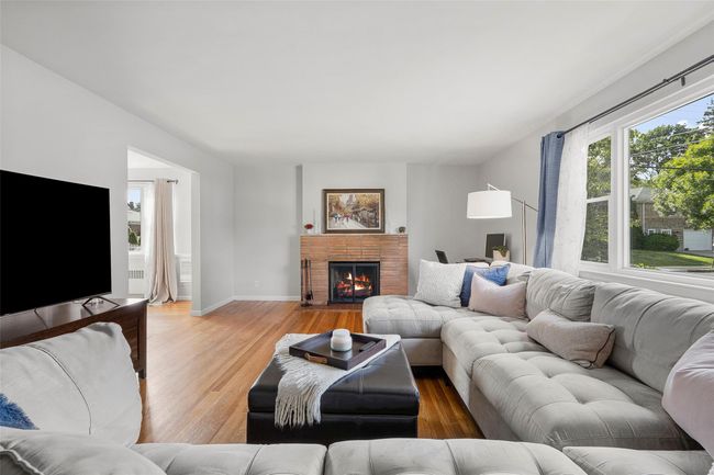 Living area featuring light wood-style floors, baseboards, and a brick fireplace | Image 4