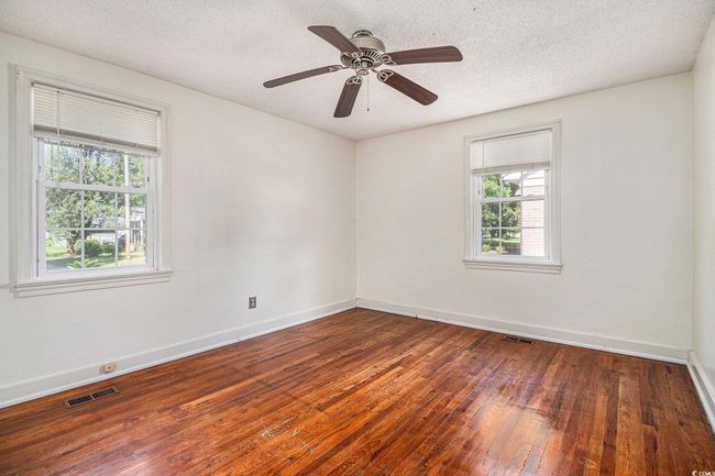 Unfurnished room featuring healthy amount of natural light, wood-type flooring, a textured ceiling, and a ceiling fan | Image 11
